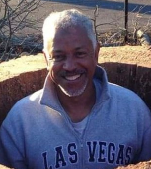 An old man with white hair smiling at camera